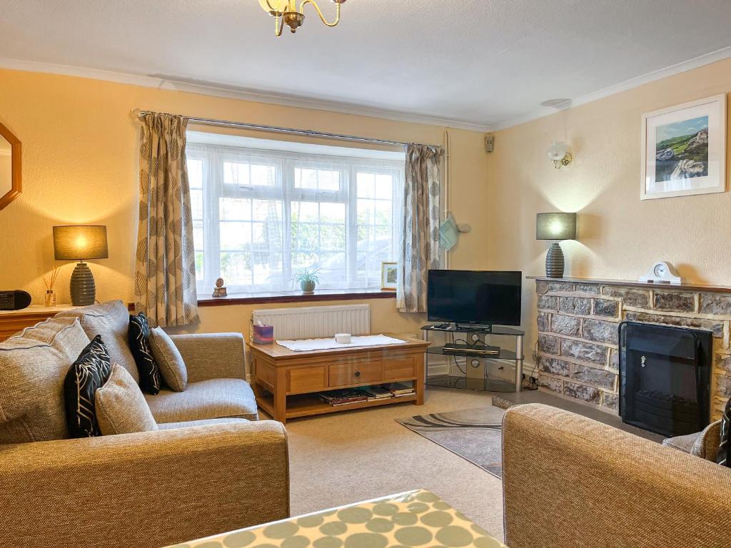 a living room with a couch and a fireplace at Eastry Cottage in Castleton