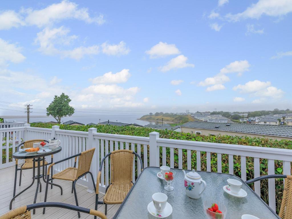 a table and chairs on a balcony with a view of the ocean at Bay View 34 in Weymouth