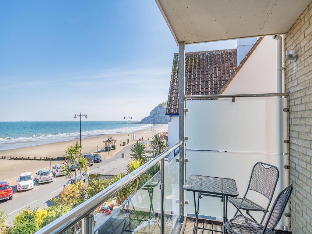 a balcony with chairs and a view of the beach at Bay View in Shanklin