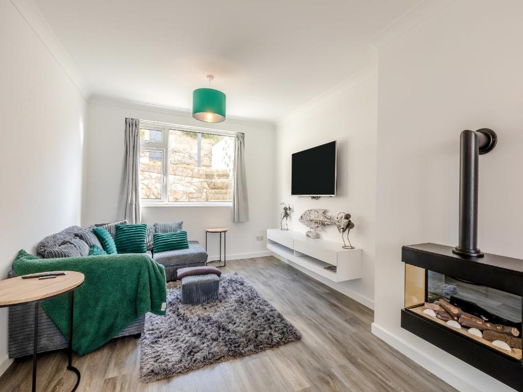 a living room with a couch and a fireplace at Driftwood Villa in Brixham