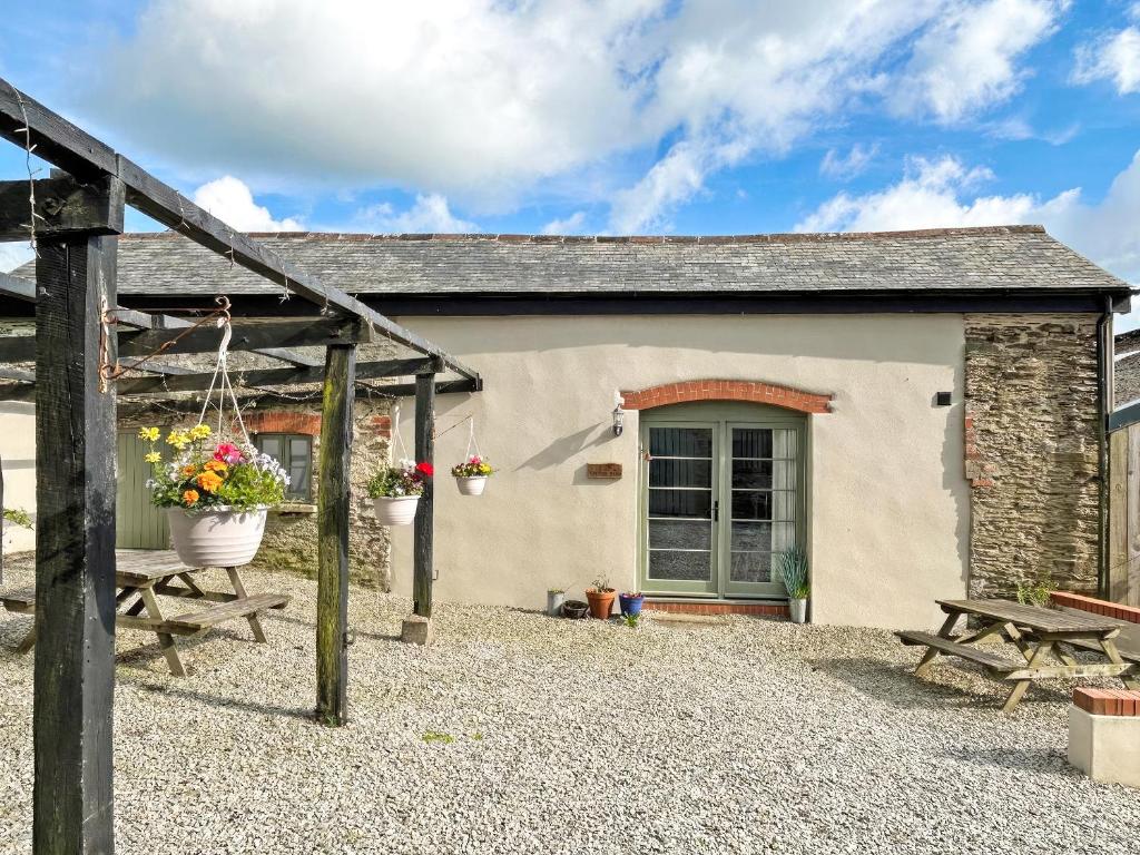 a cottage with a picnic table and a bench at The Calving Barn - Uk49679 in Bratton Fleming
