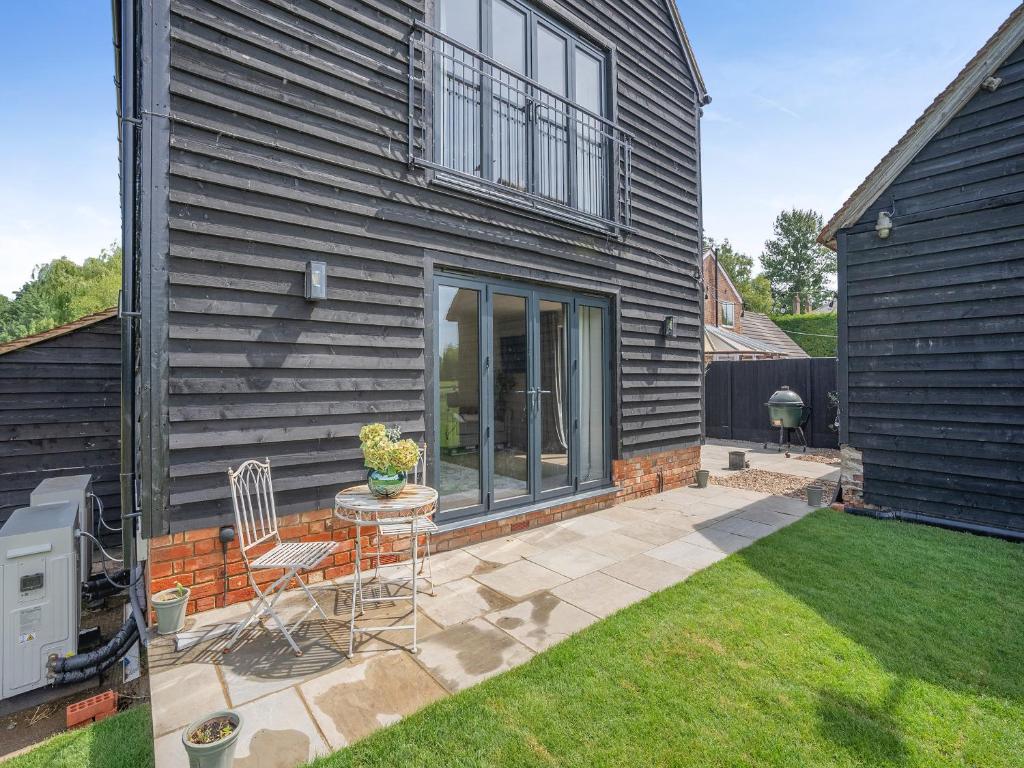 a patio with a table and chairs in front of a house at Moat Farm in Tring