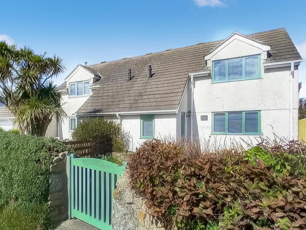 een wit huis met een groen hek ervoor bij Chy An Mordros in Hayle
