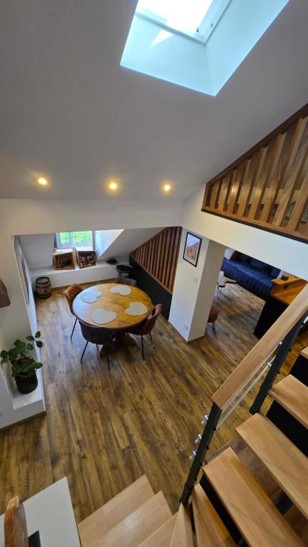 a living room with a table and a staircase at Appartement atypique au cœur de Sallanches in Sallanches