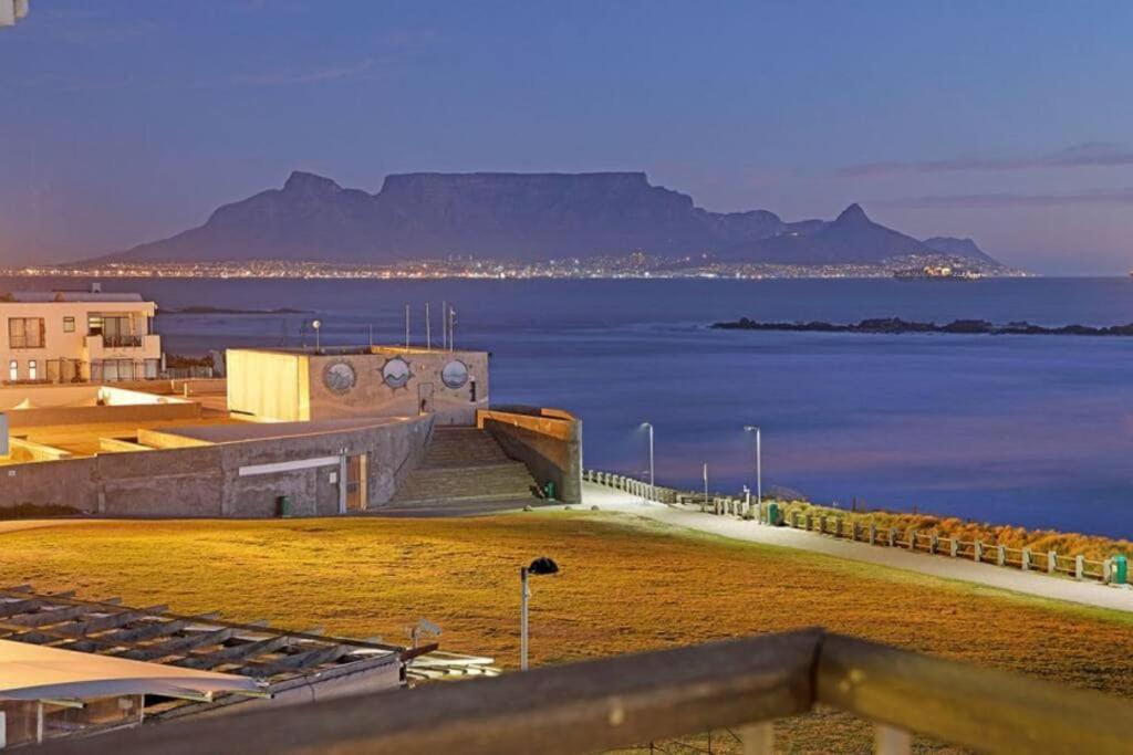 a view of the ocean with mountains in the background at Executive Apartment with Ocean Views in Blouberg in Big Bay