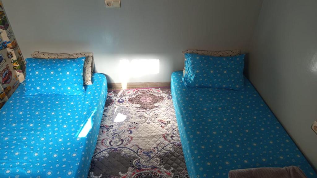 un sofá azul sentado en una esquina de una habitación en Joli appartement 2 chambres à Agadir, en Agadir