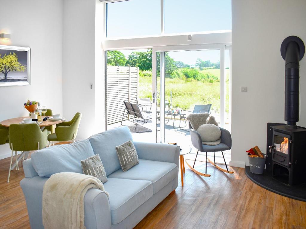 a living room with a couch and a fireplace at The Old Tractor Shed - Uk49681 in Witheridge
