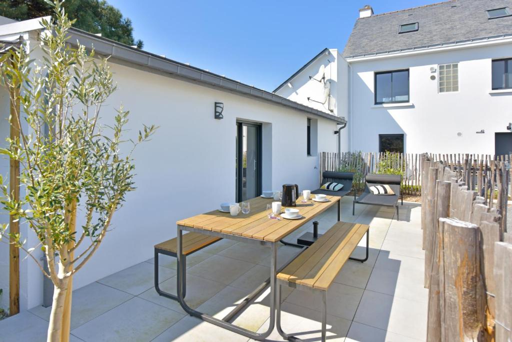 a patio with a wooden table and benches at Piriac Dumet Appartement Duplex avec exterieur 4 à 6p 500m de la plage in Piriac-sur-Mer