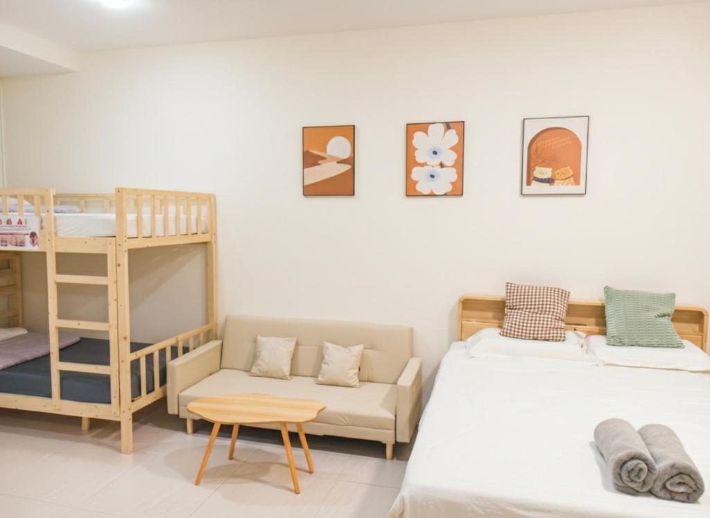 Riverine Diamond 7 RDB Studio CK - Free 1 Parking, Netflix & Cozy Retreat Couples, Families في كوتشينغ: غرفة نوم بها سريرين وسرير بطابقين وأريكة
