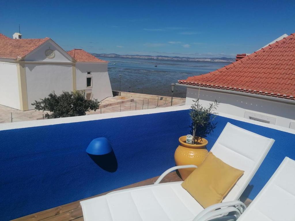 Un balcón con una pared azul y una silla. en Blue Terrace, en Alcochete
