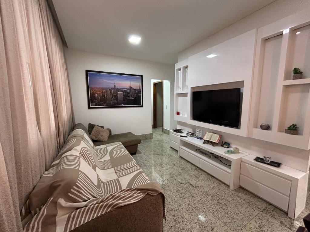 a living room with a couch and a flat screen tv at Raridade Cachoeiro, Apto 2 Qtos, Ar, Ferroviários in Cachoeiro de Itapemirim