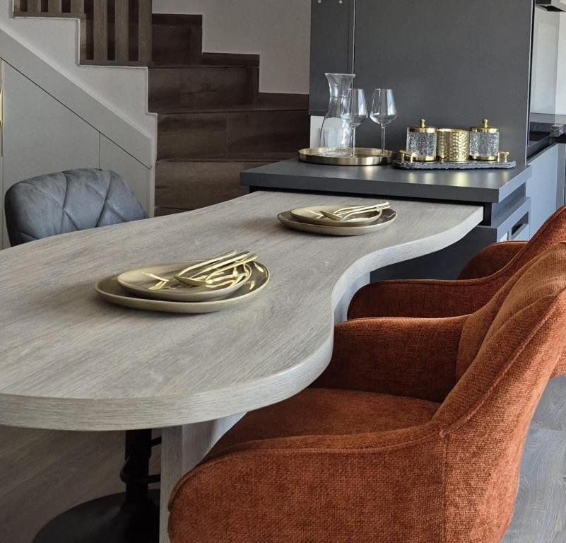 una mesa de comedor con placas de oro. en Casa Sunset, en Sînpetru