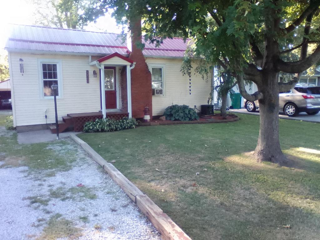 a white house with a tree in the yard at Cozy 2 Bedroom Home in Madison