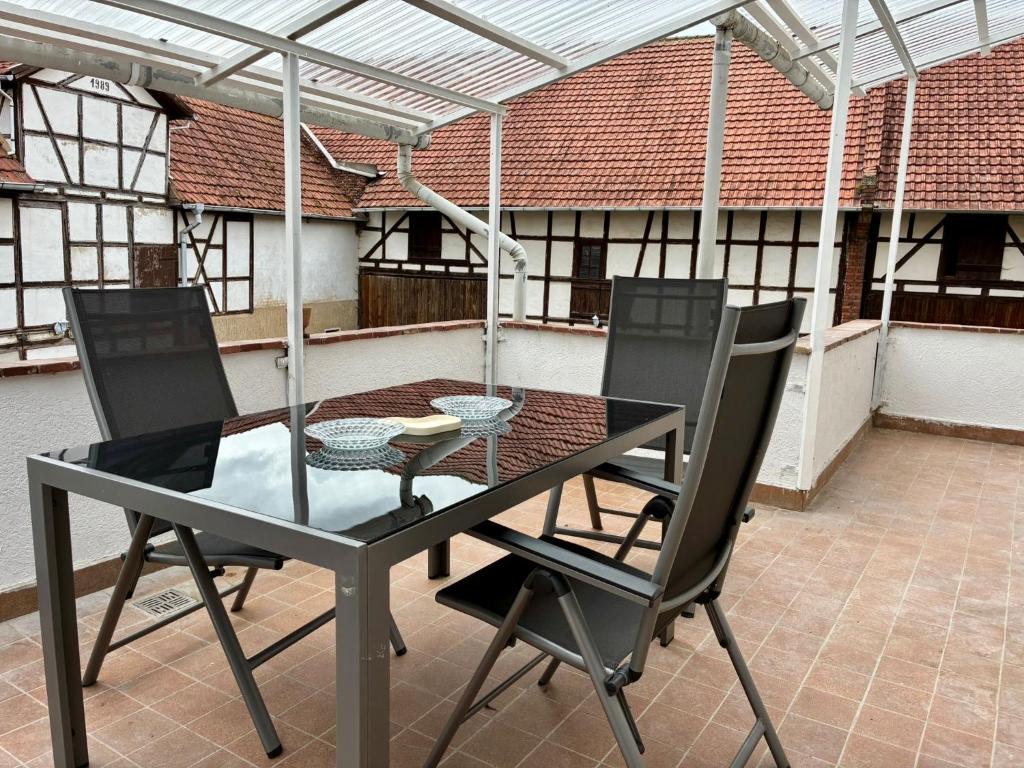 a table and chairs on a patio with a roof at Hofquartier in ruhiger Lage Eisenach & Hainich in Beuernfeld