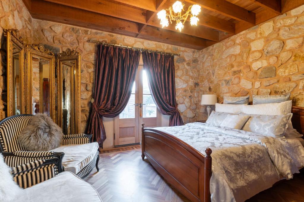 ein Schlafzimmer mit einem Bett und einer Steinwand in der Unterkunft Adelaide Heritage Home with Vintage Charm in Evandale