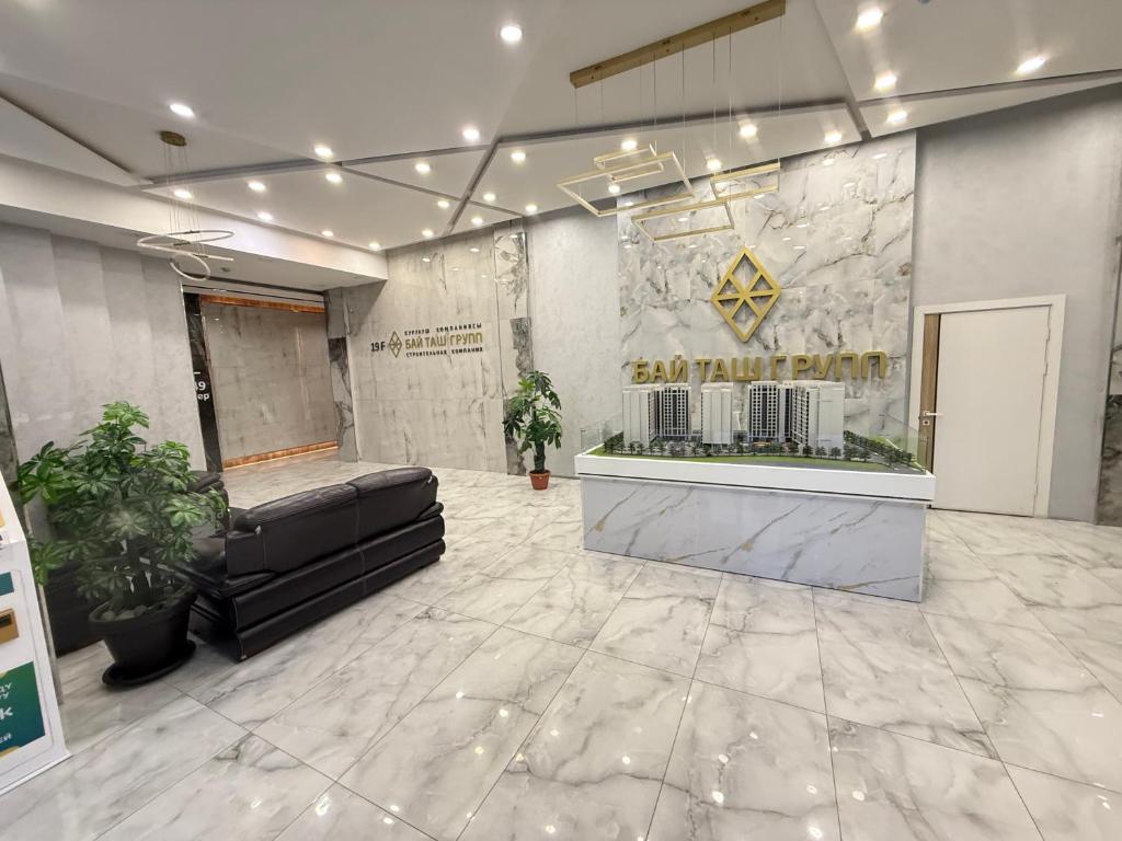 - un hall avec un canapé en cuir dans un bâtiment dans l'établissement Bay tash, à Bishkek