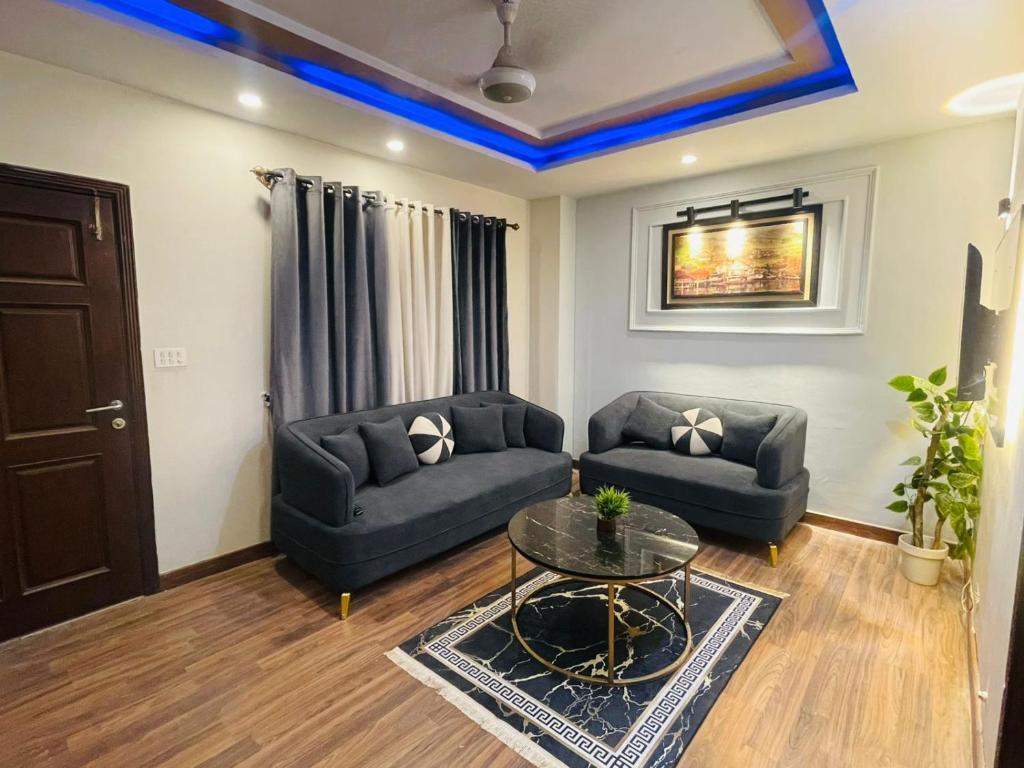 a living room with two couches and a table at Modern 2BHK Islamabad in Islamabad