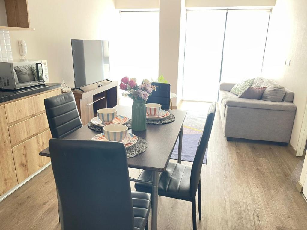 a dining table and chairs in a living room at Departamento Frente al CC el Polo in Lima