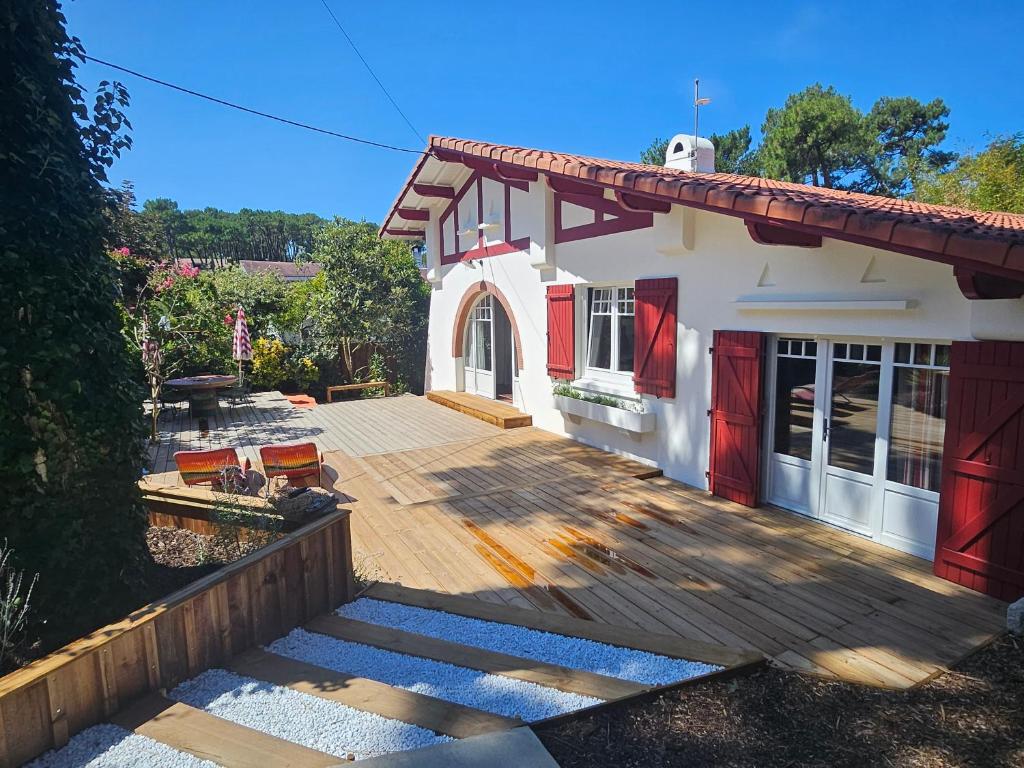 a house with a wooden deck in front of it at Maison de charme au Canon in Lège-Cap-Ferret