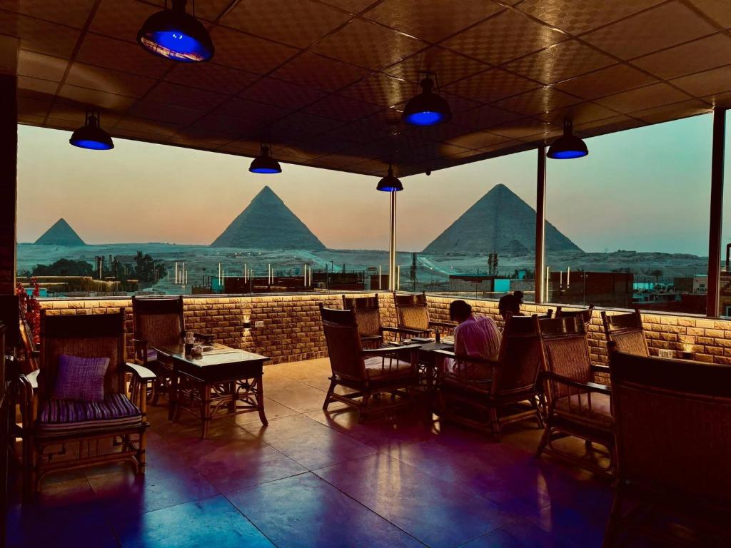 un restaurante con vistas a las pirámides en Desert Glow Pyramids INN, en El Cairo