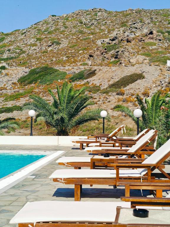a row of lounge chairs next to a swimming pool at Medina in Skala