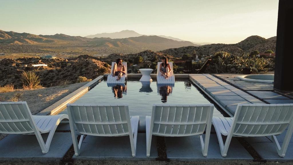 a group of three women sitting around a table with chairs at Aquarius By The Cohost Company in Yucca Valley