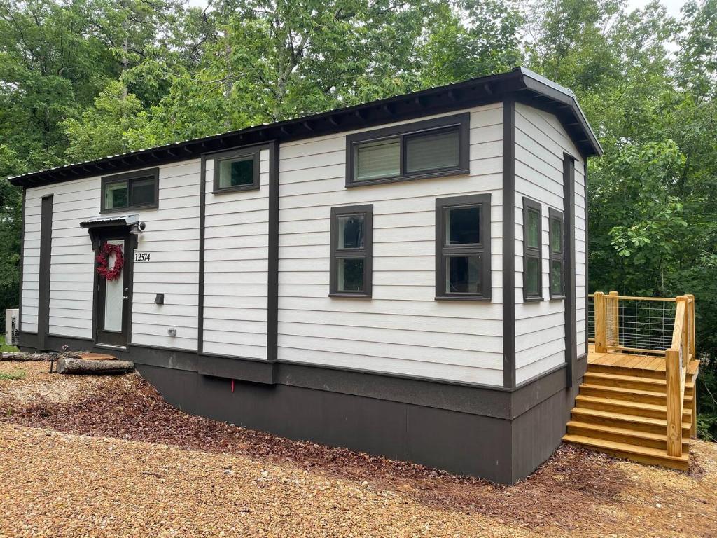 a tiny house with a staircase in a yard at Moon River Mentone 1-A Riverfront Tiny Home in Mentone