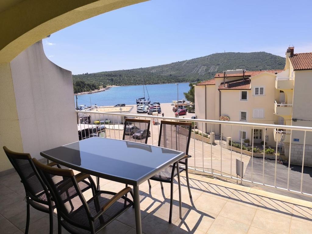 uma mesa numa varanda com vista para a água em Apartments Hrvoje em Primošten
