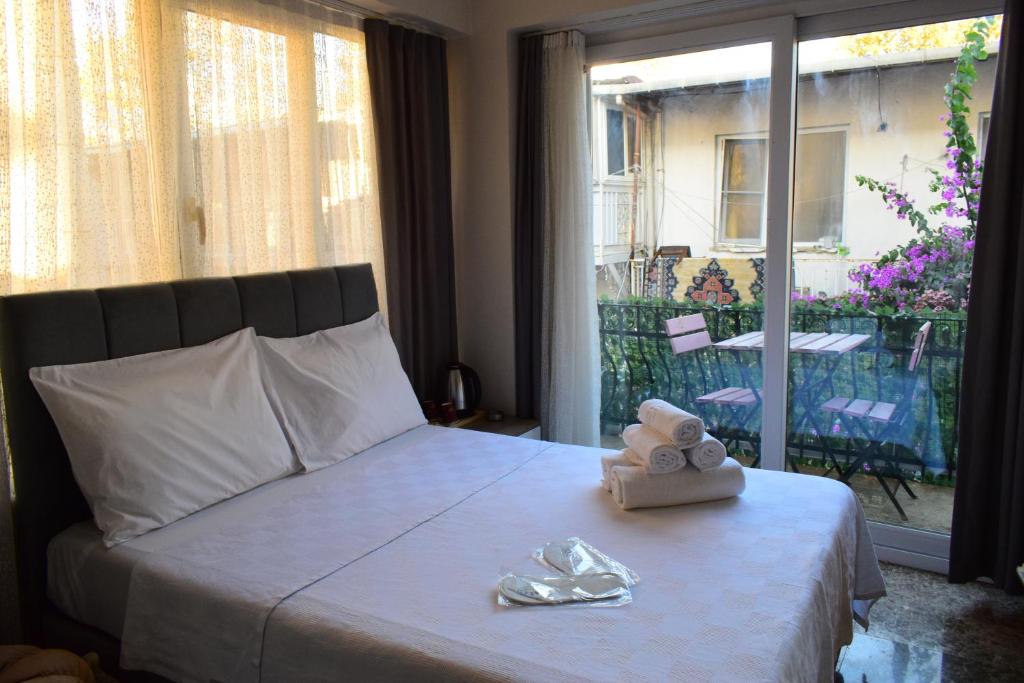 a bedroom with a bed with towels and a window at Büyükada Çarşı Pansiyon in Adalar