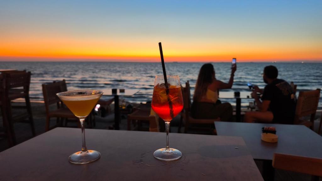 two cocktails sitting on a table with a view of the ocean at Golem Horizon apartment in Golem