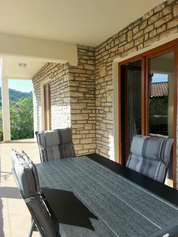 a table and chairs in a room with a stone wall at Apartment Park in Rabac