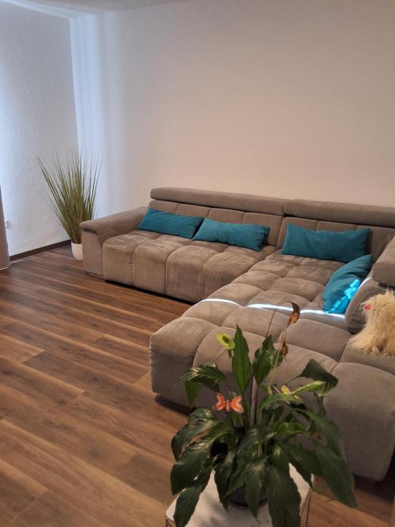 a living room with a couch with blue pillows at Ferienwohnung in Weil am Rhein