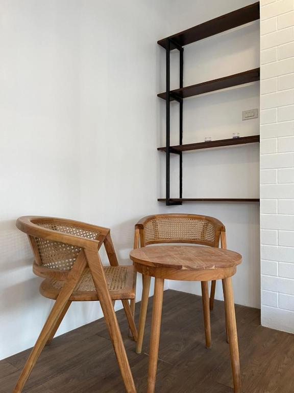 a table and two chairs and a table and a shelf at Samui 2 Bedroom Apartment - Near Beach & Night Market in Ban Lamai