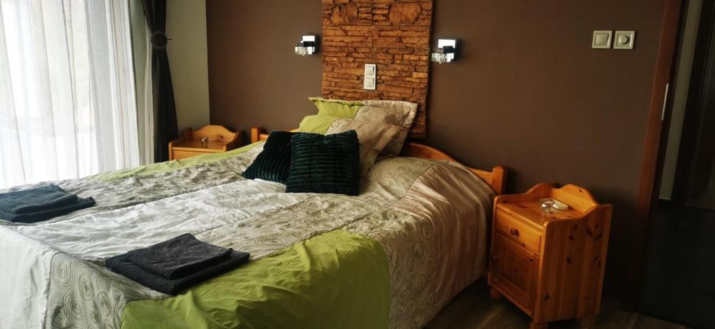 a bedroom with a bed with pillows on it at Rózsás Vendégház in Szólád