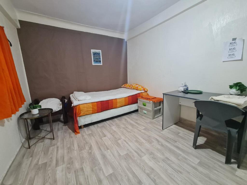 Una pequeña habitación con una cama y un escritorio. en Camera Agadir, en Agadir