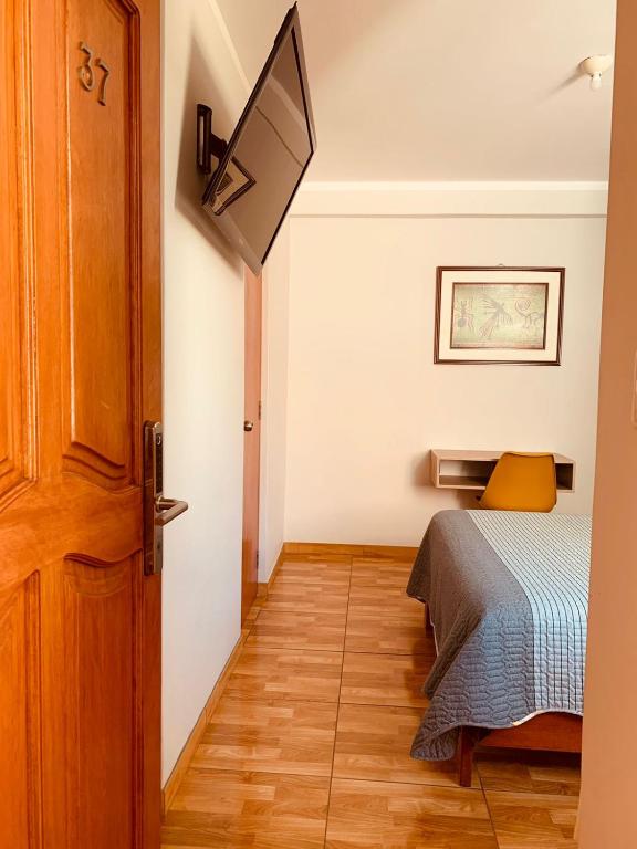 a small bedroom with a bed and a door at Hotel Silver in Tacna