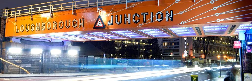 伦敦2 bed flat, sleeps 8, driveway, 5 Mins to Brixton的夜晚的城市街道上的一座桥