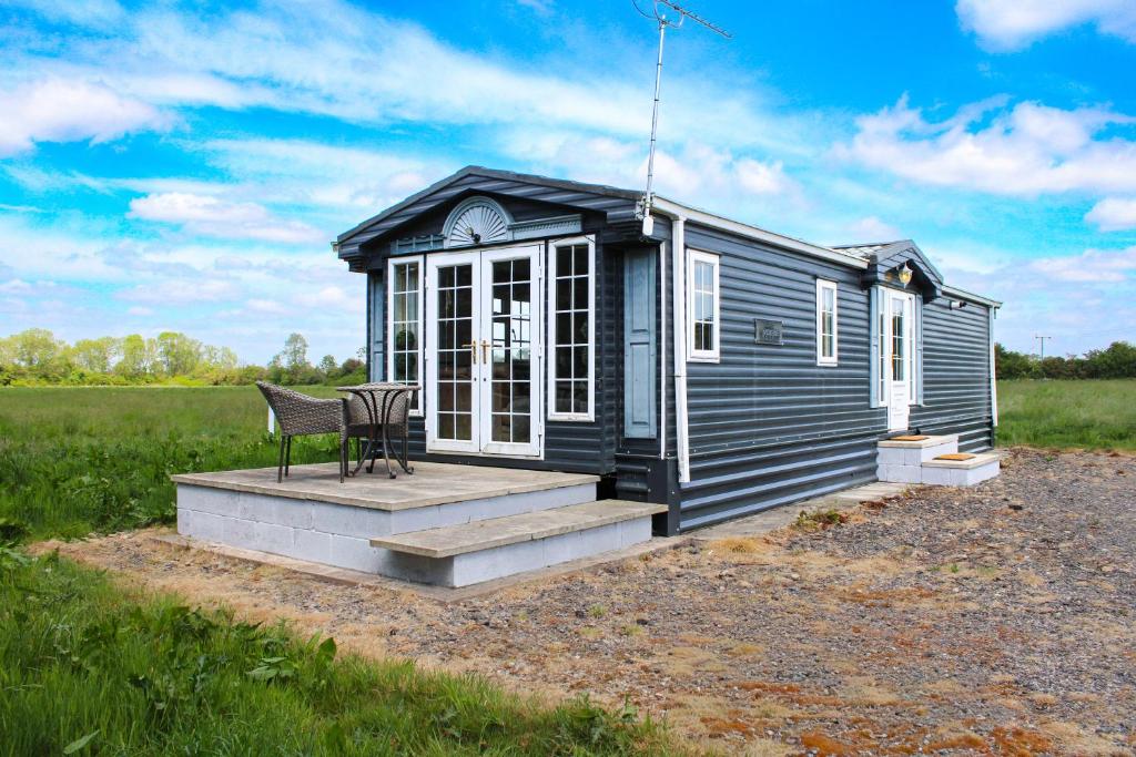 una casetta nera in un campo di Perfect Couple Retreat, Puppy Lounge & Games Room a Newton by Toft