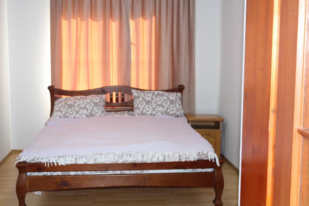 a bedroom with a bed and a window with curtains at 2х місна кімната з видом у сад in Delyatyn