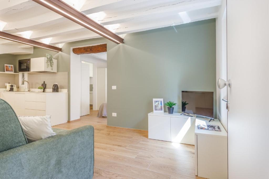 un soggiorno con divano e cucina di Corso Adriano 13 - I Giardini a Modena