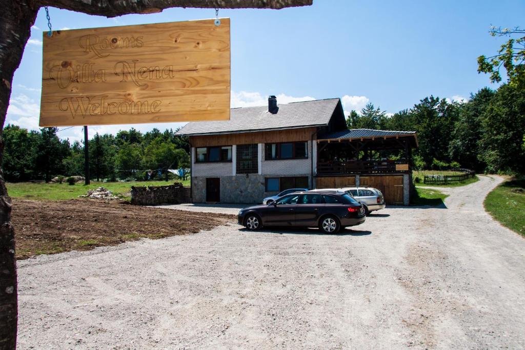 un coche aparcado frente a una casa con un cartel en B&B Villa Nena, en Plitvica Selo