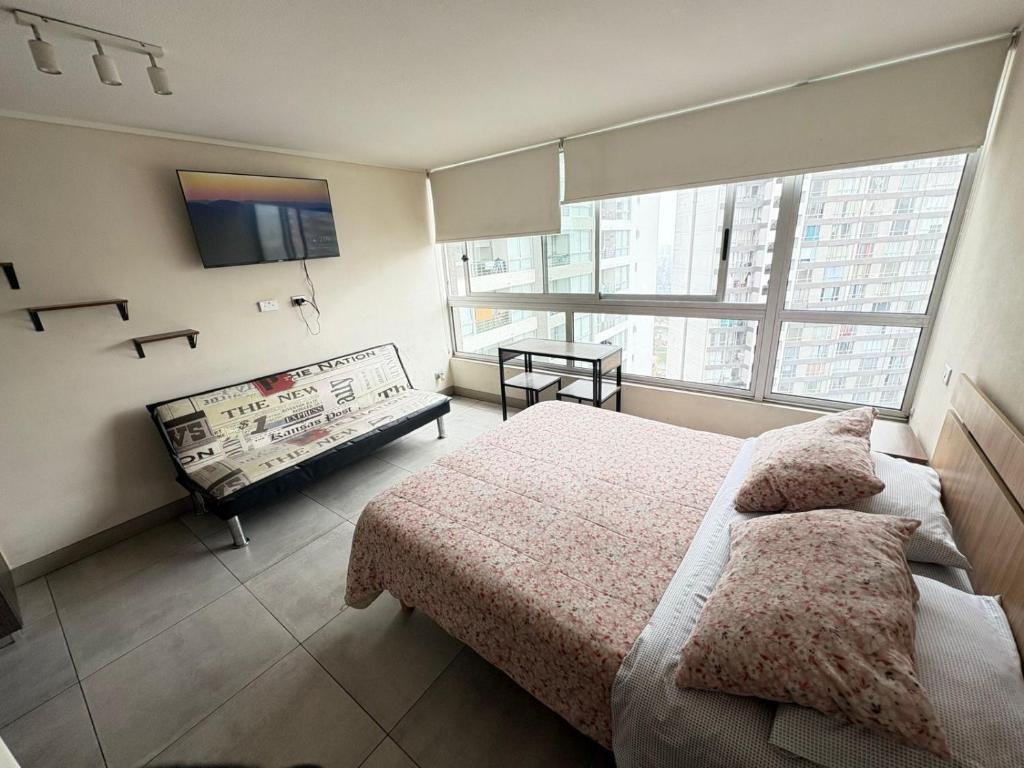 a bedroom with a bed and a large window at SantiagoCentral in Santiago