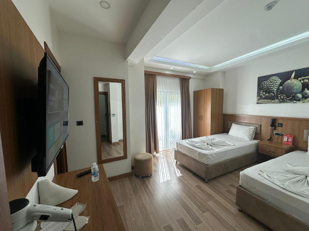 a hotel room with two beds and a flat screen tv at Hotel La SERA in Istanbul