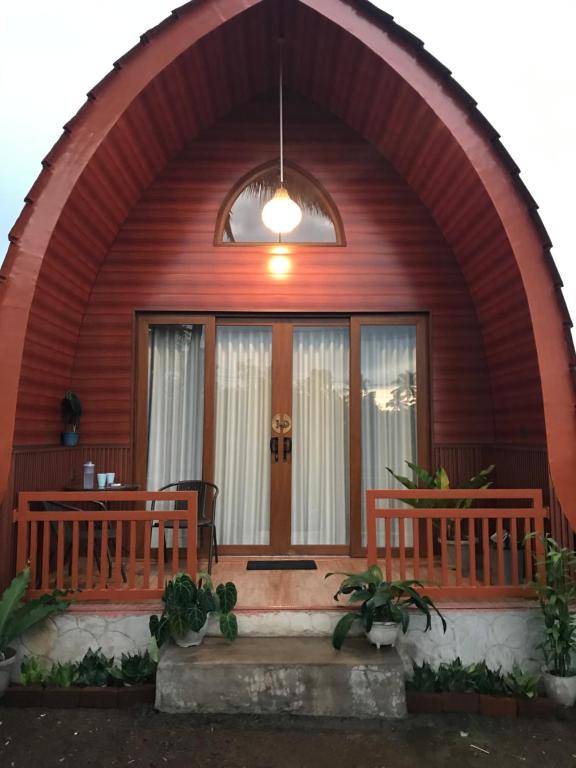 a wooden house with two benches in front of it at Bale Rinjani Bungalows in Tetebatu