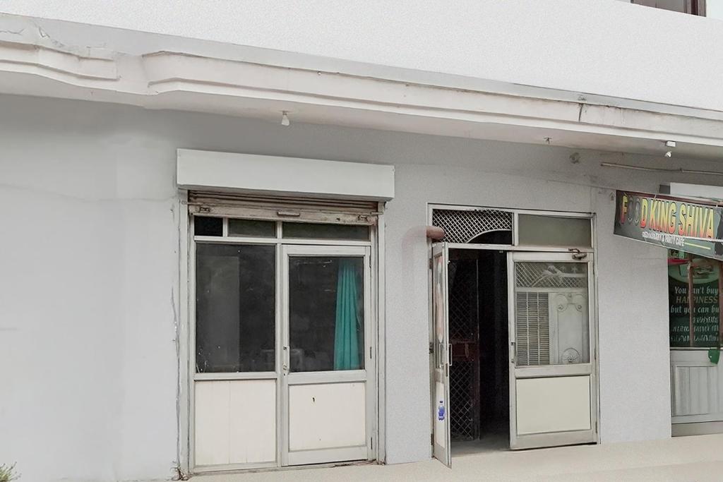 Un edificio blanco con dos puertas y un cartel. en Hotel O Vip Stay Inn, en Ghaziabad