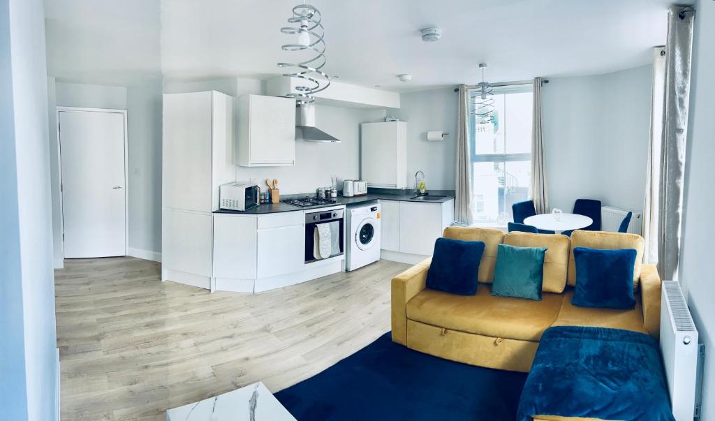 a living room with a couch and a kitchen at Folkestone Harbour Flat 2BR sleeps 4 in Folkestone