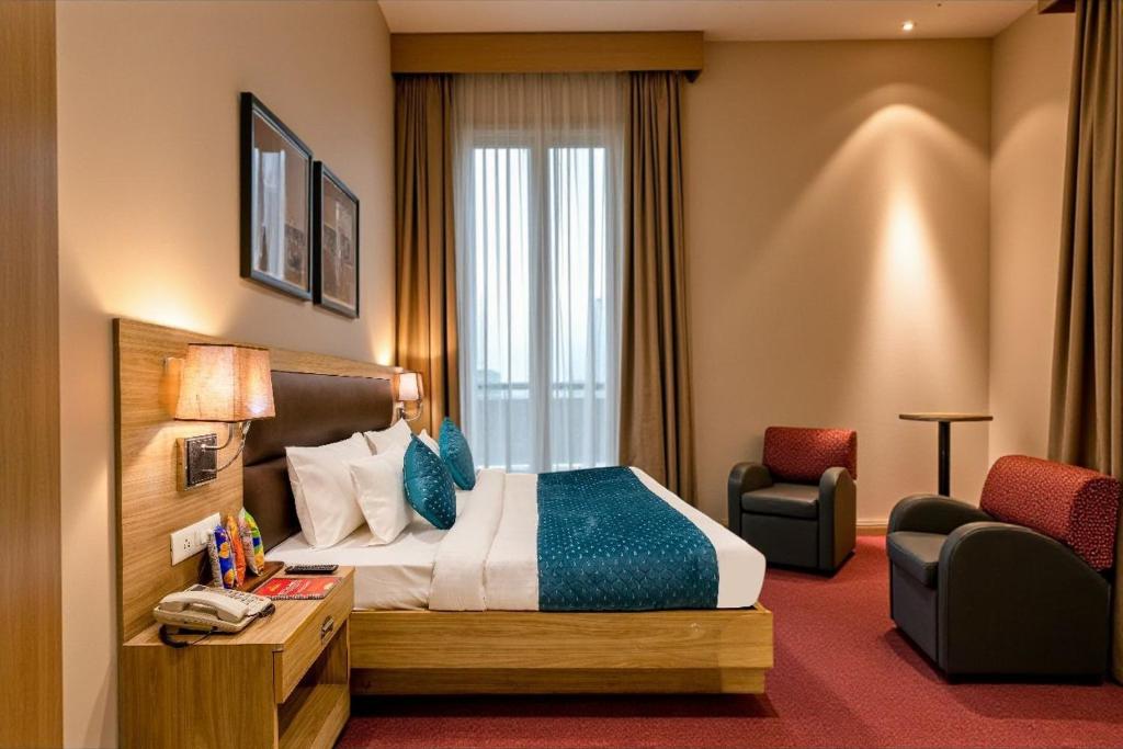 a hotel room with a bed and a chair at Hotel Salt N Rove Near Terminal 3 Delhi Airport With Free Airport Pickup in New Delhi