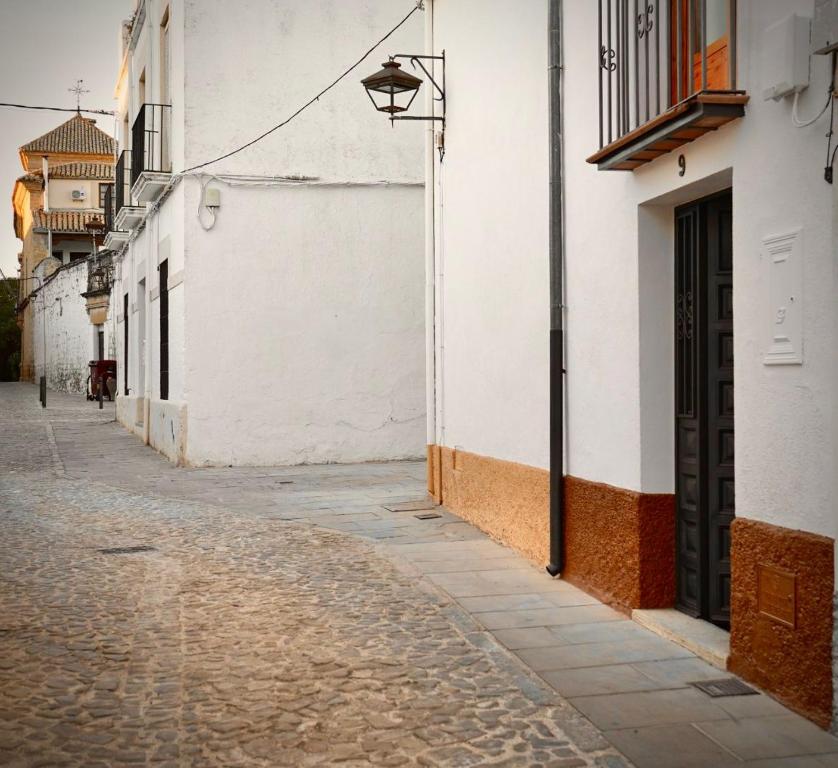 an empty alley with a white building and a door at Alojamiento la Morada de la Luz in Úbeda