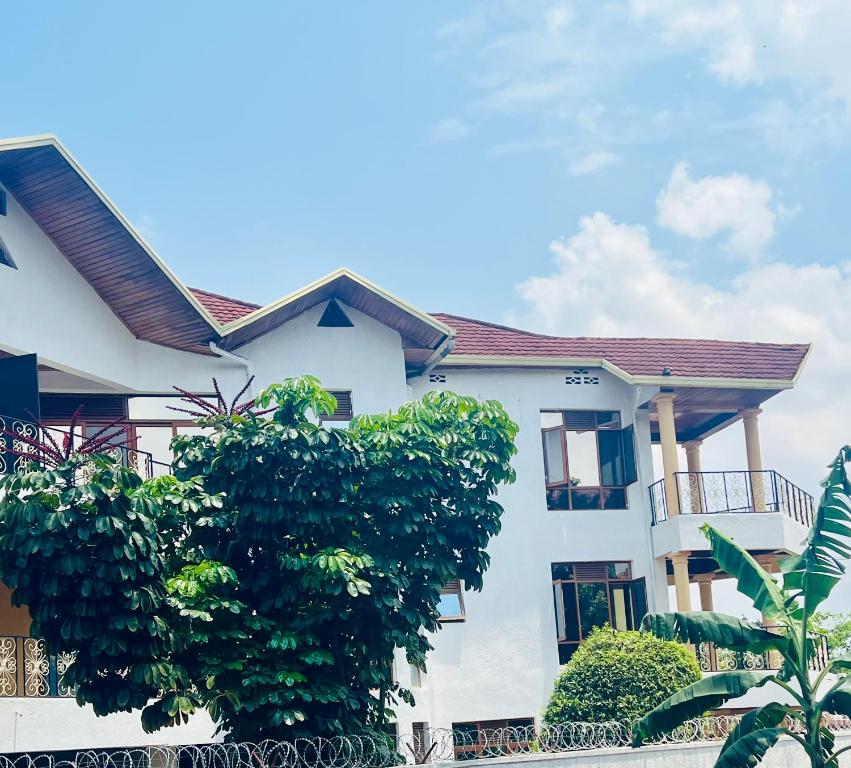 una casa blanca con árboles delante en KIGALi LODGE APART, en Kigali