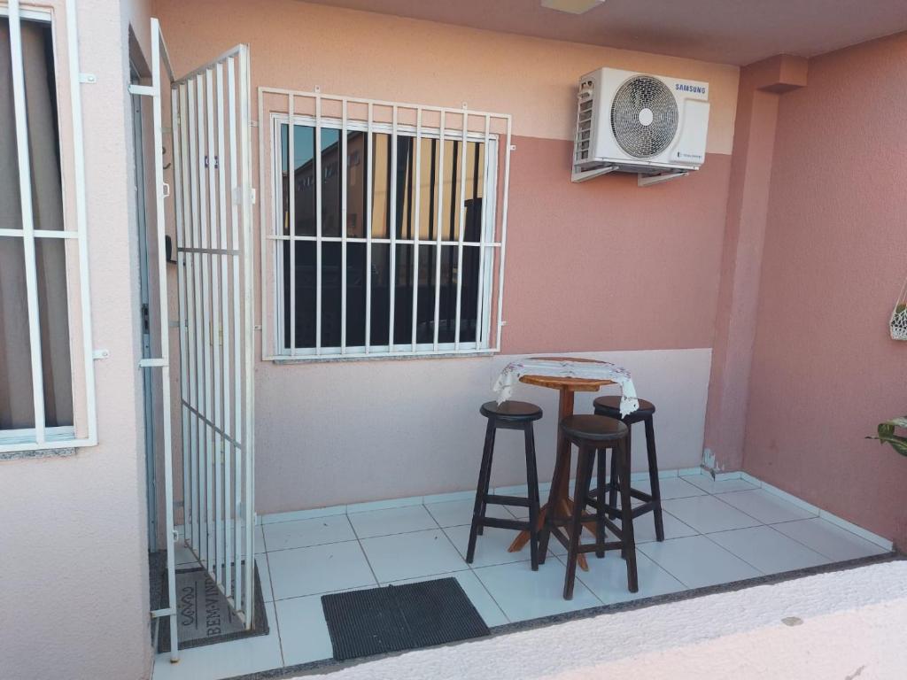 a room with a table and stools and a fan at Andrea in Petrolina